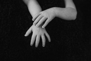 Foto en blanco y negro de las manos de gemelos recién nacidos