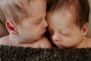 Gemelos recién nacidos durmiendo cara a cara