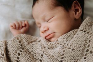 Fotografía de recién nacido durmiendo en la cama - sesión a domicilio en El Puerto de Santa Maria
