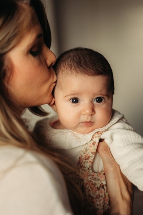 Mamá besando a su bebé de dos meses y medio